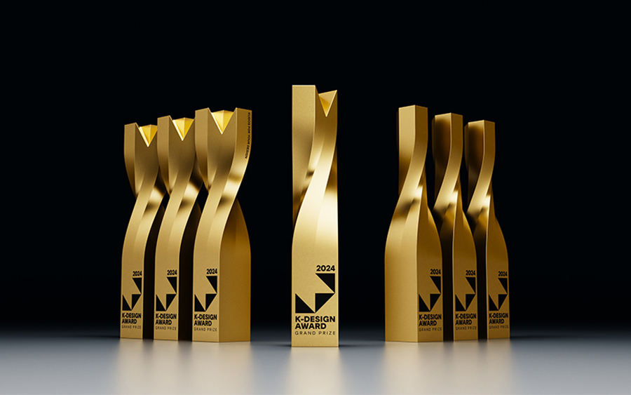 Siete trofeos K-Design Award dorados con la torsión vista desde distintos ángulos y una pieza central de frente